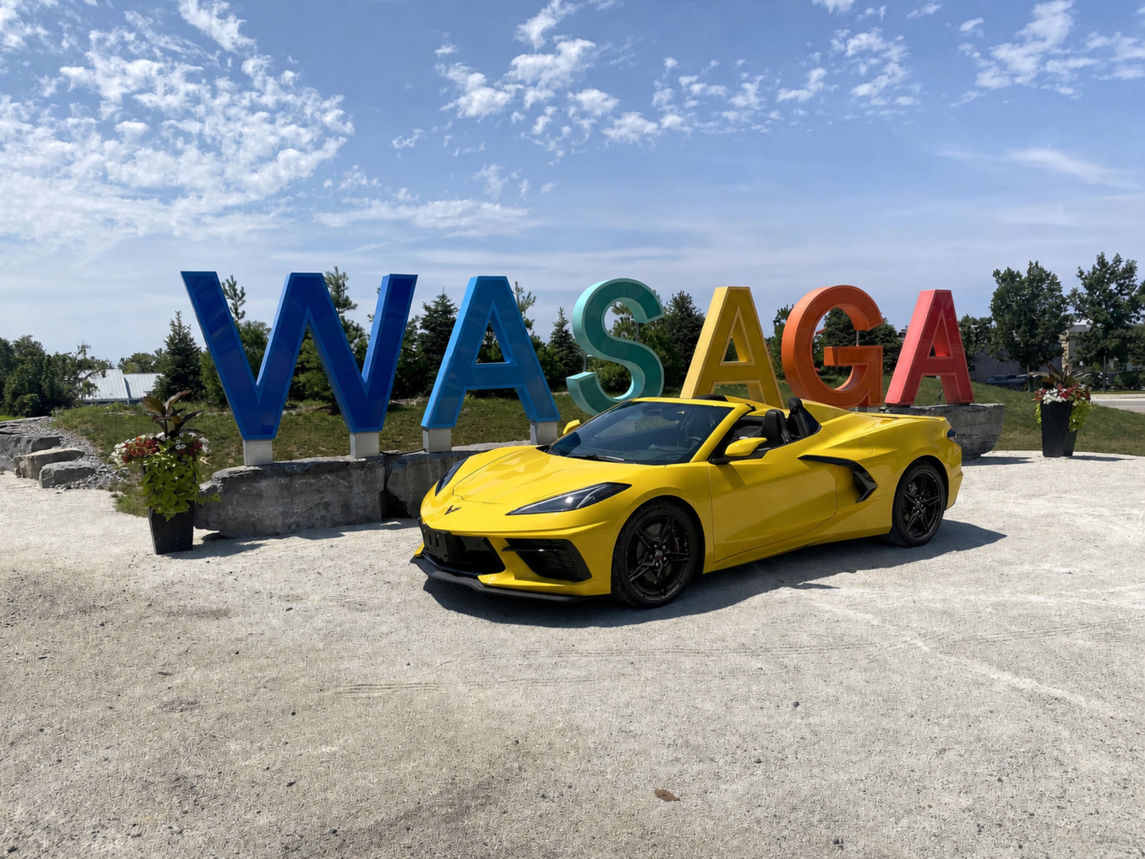 Corvette at Wasaga Beach with Black Rims Yellow Corvette with black rims displayed beside the Wasaga Beach sign